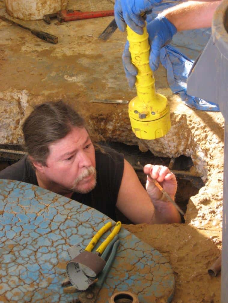 One of HEB Plumbing and Sprinkler's licenced professional plumbers starts work under a home's foundation
