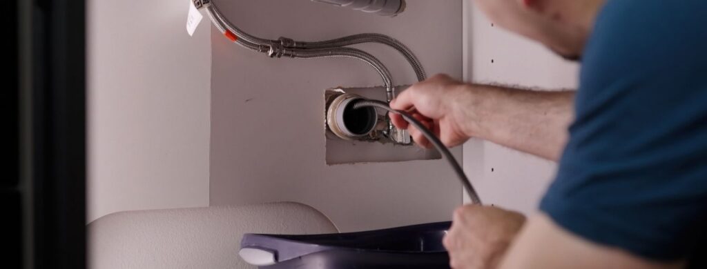 A plumber working on ficing a clogged pipe.